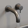 Wall Mounted Matte Black Faucet With Water Flowing From Sleek Spout On Gray Wall
