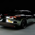 Sleek Black Modern Car Driving On Road With Aerodynamic Body And Sporty Wheels