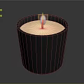 Lit Candle In Black Container With White Wax And Decorative Label