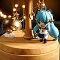 Festive Carousel Decoration With Blue Haired Figure Stars Small Houses And String Lights