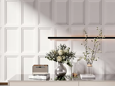 White Aquatic Plants in Silver Vase on Glass Table with White Paneled Wall and Black Pendant Light 3d model