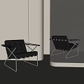 Two Modern Black Leather Accent Chairs With Sleek Metal Frames And Contemporary Interior