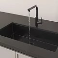 Black Kitchen Sink With Running Water From Black Faucet On Sleek Countertop And White Cabinets