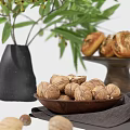 Delicious Bread and Walnuts on Wooden Tray with Green Plants Black Vase and Gray Cloth