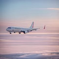Modern White Passenger Jet Flying Over Clouds in Sunset Sky