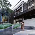 Modern Plaza Landscape with High Rise Buildings Trees Shaded Canopy Smooth Stone Pavement and People
