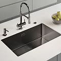 Modern Kitchen Faucet on Stainless Steel Sink with Soap Dispenser and Bowl of Green Apples