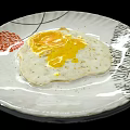 Tasty Fried Egg With Runny Yolk On White Plate With Red Floral Pattern
