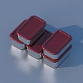 Three Household Metal Containers with Red Lids on Smooth Shiny Surface