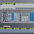 Industrial Factory Plant Featuring Multiple Buildings Blue Roofs Trucks And Surrounding Greenery