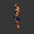 Muscular Man Standing with Well Developed Physique in Blue Shorts Against Gray Background