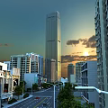 Urban Road Infrastructure With Street Lamps And High-Rise Buildings At Sunset