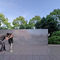 Modern Perforated Metal Fence In Outdoor Area With Green Trees And Paved Surfaces