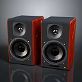 Modern Bookshelf Speakers With Red Wooden Finish And Black Speaker Cones On Reflective Surface