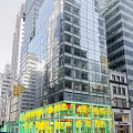 Bright Modern Commercial Storefront Window Display Along Downtown Urban Street Beneath Glass Curtain Wall Building