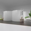 Modern Exhibition Booth with White Curved Walls Green Plants Dark Floor and Display Furniture