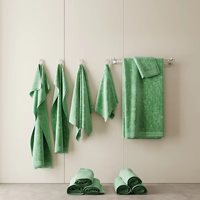 Set of Green Towels Hanging On Metal Hooks Against Beige Wall In Bathroom 3d model