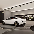 4S Shop Showroom Featuring White Car on Circular Display Platform With Car Posters on Back Wall