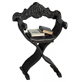 Ornate Black Carved Wooden Stool With Crossed Legs Armrests And Stacked Books On Seat