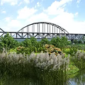 Scenic Natural Landscape With Arch Bridge Lush Green Vegetation Calm Water And Blue Sky