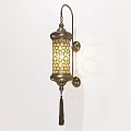 Traditional Brass Wall Lamp with Intricate Geometric Cutout Shade Tassel and Patterned Light Projection