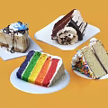 Assorted Cake Slices With Rainbow Layers Chocolate Cream And Sprinkles