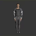 Man Wearing Gray Long Sleeve Top and Pants Standing in Studio with Gray Background