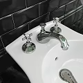 White Toilet with Pedestal Sink in Bathroom with Black Tiled Wall