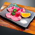 Sliced Raw Beef with Broccoli Lemon Slice and Salt on Black Plate Over Wooden Board