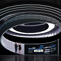 Modern Technology Exhibition Hall With Two People At Display Counter And Spiral Lighting Design