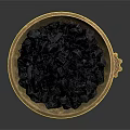 Golden Decorative Bowl With Intricate Base Holding Black Granules And Small Gear