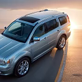 Silver SUV With Sunroof And Alloy Wheels Parked On Sunset Road With Sleek Exterior Design