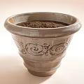Light Colored Ceramic Planter With Carved Patterns And Soil Inside