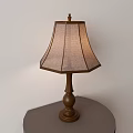 Classic Brown Wooden Table Lamp With Beige Fabric Shade On Round Metal Table