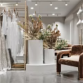 Elegant Bridal Shop with Grey Lace Wedding Dress on Display Platform and Hanging Bridal Gowns
