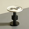 Round Side Table Featuring White Tabletop Black Geometric Base With Silver Balls And Book