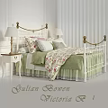 White Iron Bed With Gold Accents Green Quilt Floral Pillows And Bedside Lamp