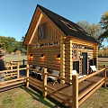 Wooden Coffee House With Black Roof Terrace Chairs Tables Green Lawn And Trees
