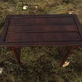 Dark Wooden Desk With Wooden Planks Top And Slim Legs On Grass Field