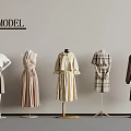 Model Mannequins Displaying Neutral Tones Dresses And Plaid Coats Against Grey Wall