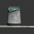 Concrete Trash Bin Setup With Green Trash Bag On Square Stone Slab