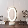 Elegant Oval Table Lamp With Illuminated Ring On Wooden Table With Books Dried Flowers Decor