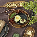 Stylish Dinnerware Set Including Plates Napkins Cutlery Avocado Nuts Glasses Vase Greenery on Linen Placemat