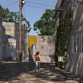 Urban Alley with Old Buildings Ivy Covered Walls and Person Walking in Sunlight