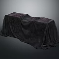 Mysterious Long Object Covered With Dark Draped Fabric On Gray Background