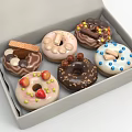 Assorted Donuts Decorated With Chocolate Fruits And Cookies In A Box