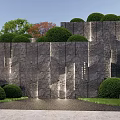Natural Textured Stone Wall Landscaped With Trimmed Bushes And Green Trees