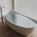 White Freestanding Bathtub With Water And Silver Faucet Near Wooden Floor