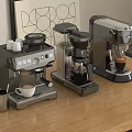 Three Metallic Coffee Machines On Wooden Table With Coffee Cups And Mug