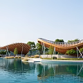 Modern Landscape Pavilion With Wavy Wooden Roof Design And Water Reflection Under Clear Blue Sky